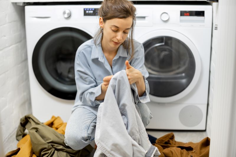 kobieta sprawdza metki przed praniem odzieży sportowej